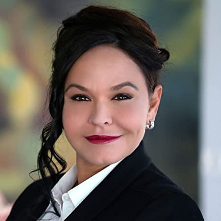 Christine Schiwietz is wearing a white button down shirt and black blazer, smiling at the camera