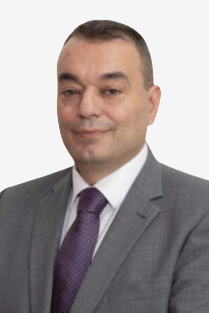 Rodolph Boughaba is wearing a gray suit with a purple tie and looking at the camera